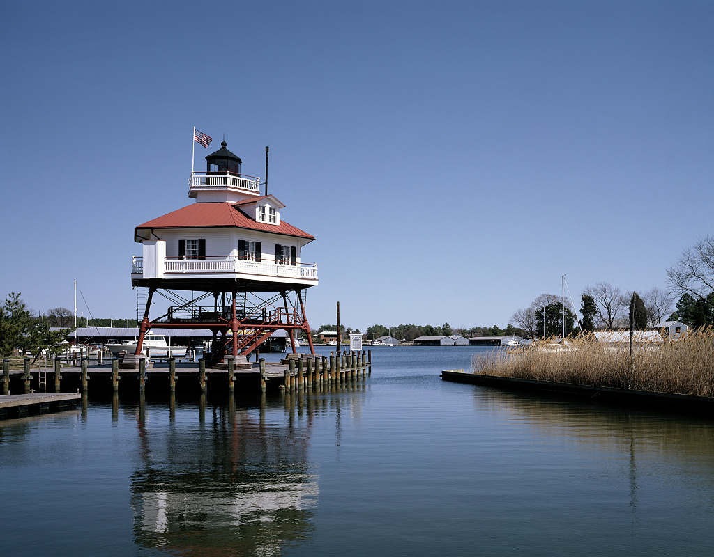 Drum Point Lighthouse on iron pilings beside the water at Calvert Marine Museum in Solomons, Maryland.