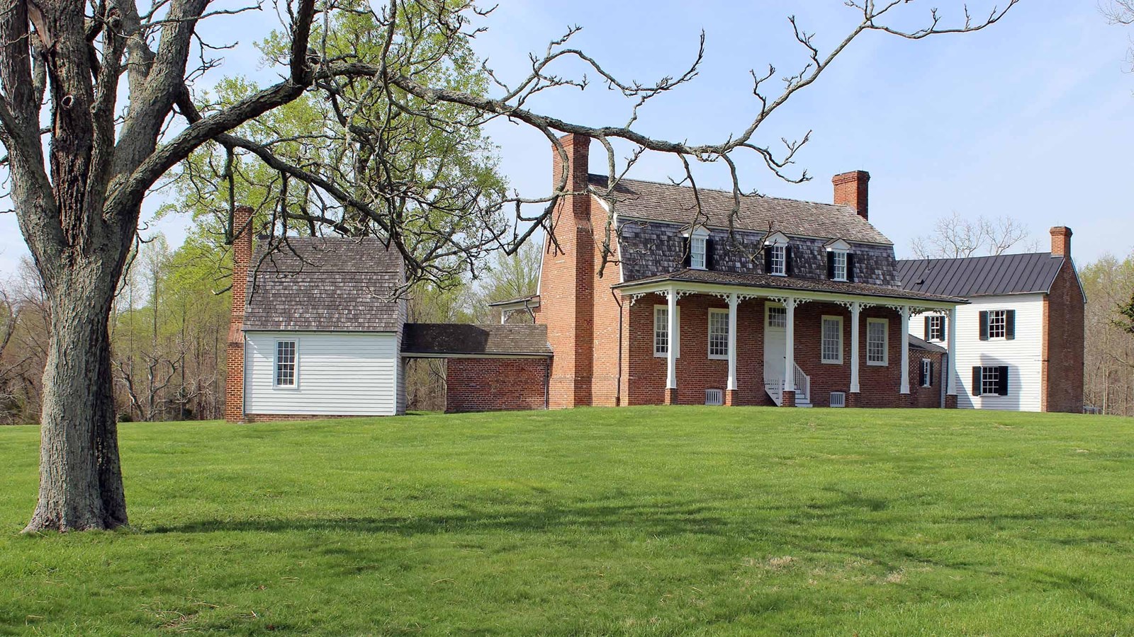The brick-and-white Thomas Stone House at Haberdeventure behind a green lawn in Charles County, Maryland.